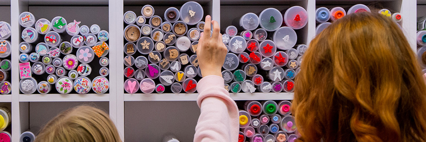 Žena a dieťa obdivujú farebnú zbierku gombíkov